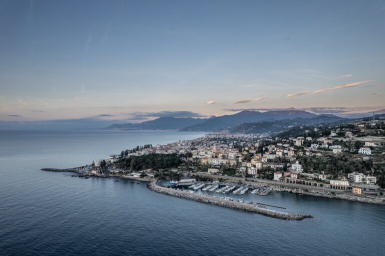Vista aerea del porto turistico e di Capo Sant'Ampelio con la città, la costa e le montagne sullo sfondo
