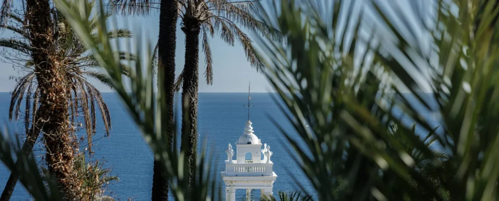 Palme e campanile bianco affacciati sul mare di Bordighera