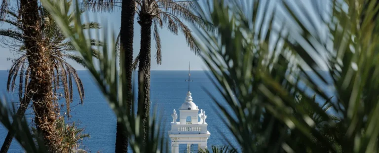 Palme e campanile bianco affacciati sul mare di Bordighera