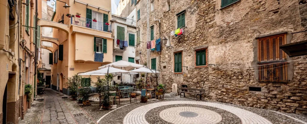 Piazzetta del borgo antico con tavolini e ombrelloni